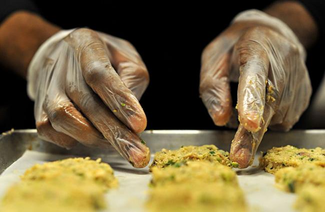 Close up of hands working some dough on a cookie sheet