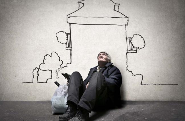 Homeless person leaning agains a wall