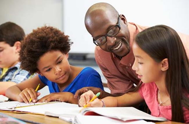 Teacher helping students at their desk