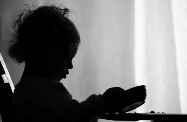 Image of a girl sitting at a table with a bowl.