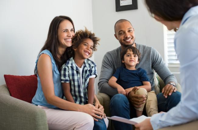 Family sitting together talking with consultant