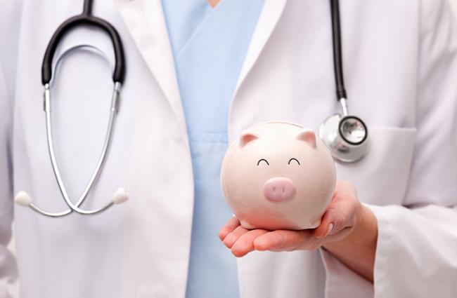 Image of medical professional holding a piggy bank.