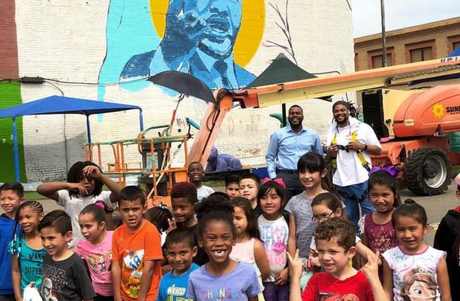 Image of a group of children in front of a mural featuring Martin Luther King, Jr.