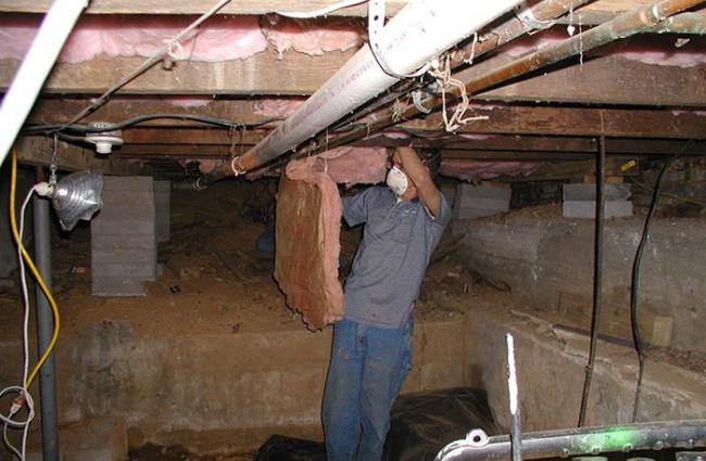 Image of a man working to weatherize a home.