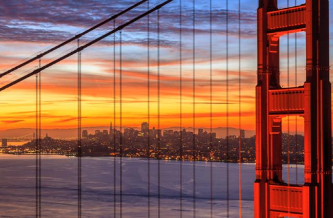 Close up of one of the Golden Gate towers in front of the sunset