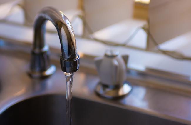 Faucet with running water into a sink