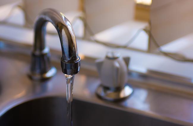 Faucet with running water into a sink