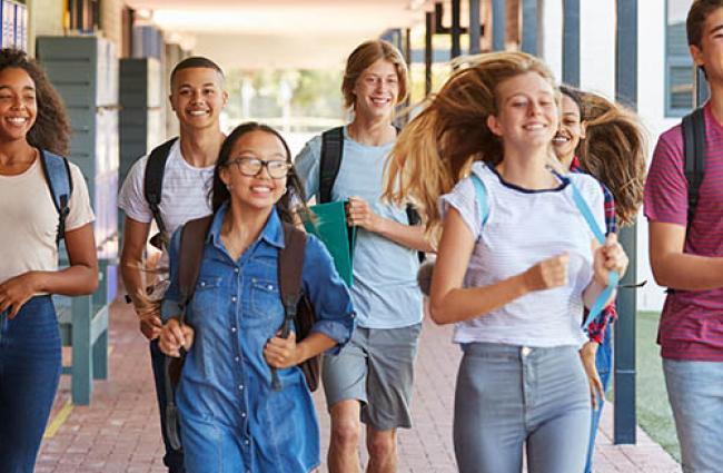 Diverse group of students at school running