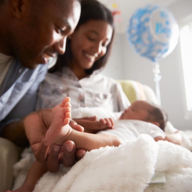 A mother and father looking at their newborn