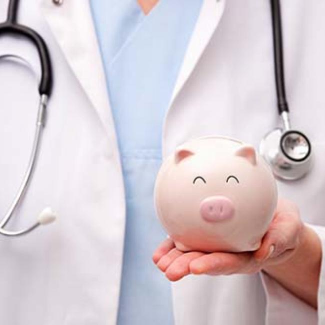 Doctor holding a piggy bank