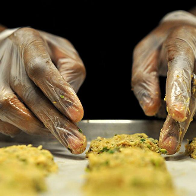 Close up of hands working some dough on a cookie sheet