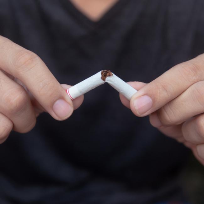 hands breaking a cigarette in half