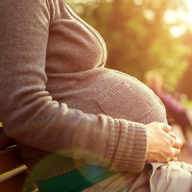 Pregnant woman sitting on park bench