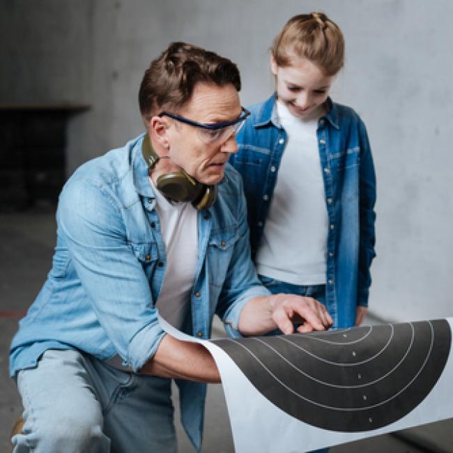 Man holding practice target talking with child