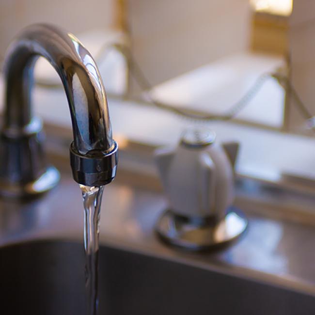Faucet with running water into a sink