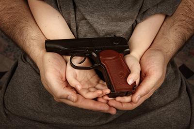 Parent and child hold a gun