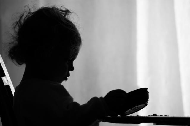 Image of a girl sitting at a table with a bowl.